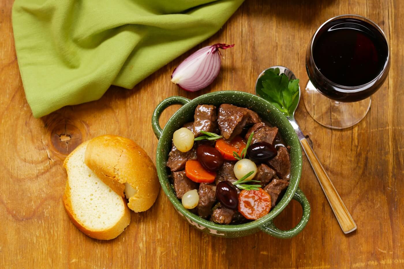 Top view of a beef stew in red wine with vegetables and herbs