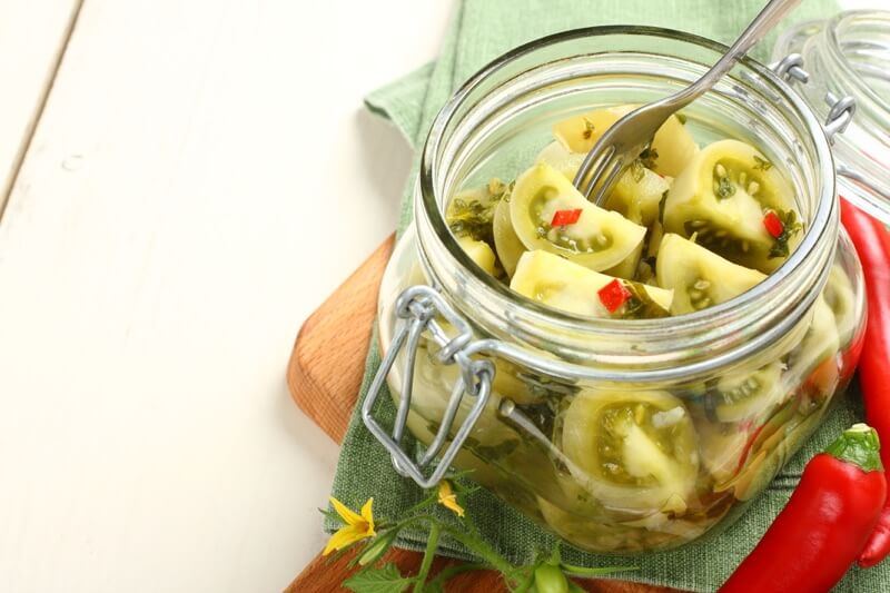 Homemade canned green tomatoes in a glass jar