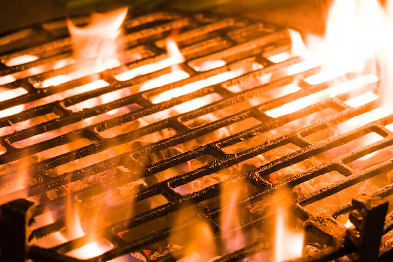 Gros plan de charbon de bois brûlé sous un barbecue.