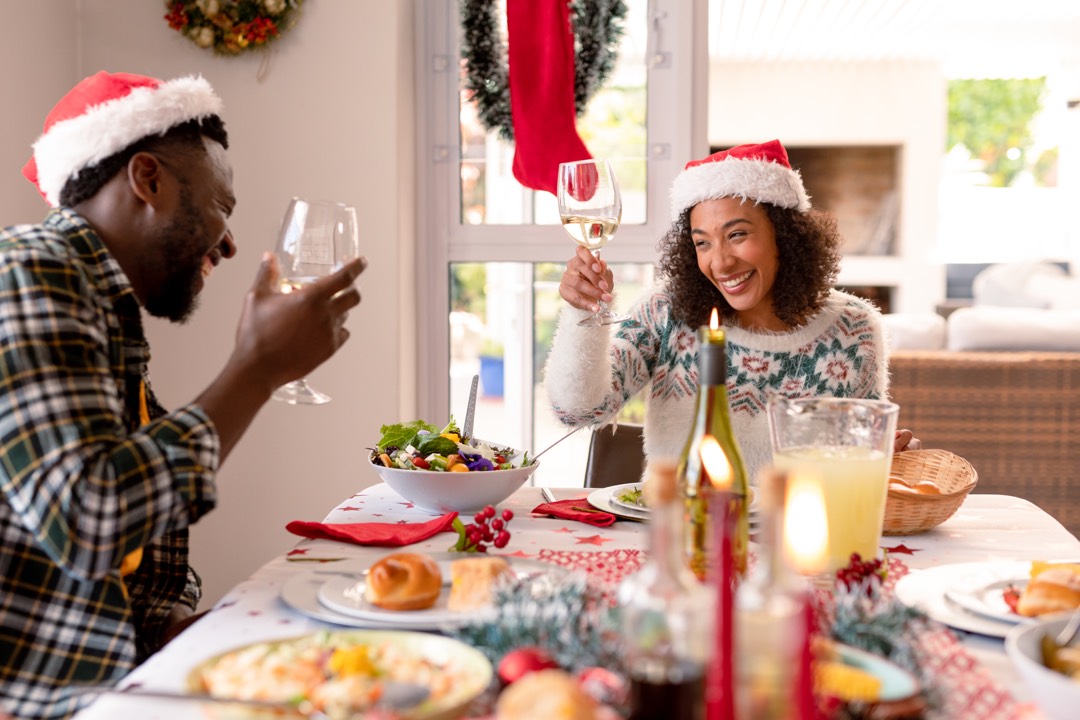 A cheerful couple making a toast at the christmas table.